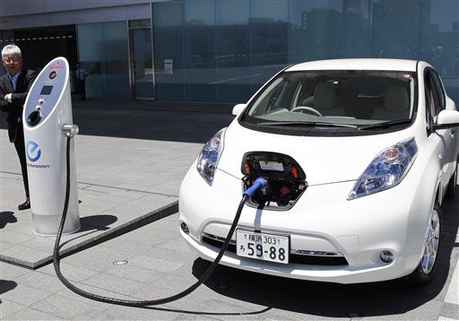 Nissan Motor Co. chief vehicle engineer Hidetoshi Kadota demonstrates a quick charge of a Nissan Leaf by a solar-assisted EV charging system at Nissan's global headquarters in Yokohama, Monday, July 11, 2011. Nissan is testing a super-green way to recharge its Leaf electric vehicle using solar power, part of a broader drive to improve electricity storage systems. In the new charging system, electricity is generated through 488 solar cells installed on the roof of the Nissan headquarters building. Four batteries from the Leaf had been placed in a box in a cellar-like part of the building, and store the electricity generated from the solar cells, which is enough to fully charge 1,800 Leaf vehicles a year, according to Nissan. (AP Photo/Koji Sasahara)